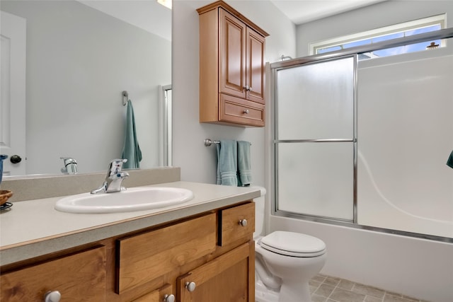 full bath with vanity, combined bath / shower with glass door, and toilet