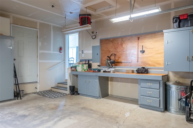 garage with a workshop area and electric panel