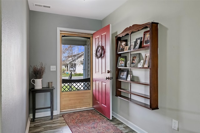 entryway featuring baseboards, dark wood finished floors, and visible vents
