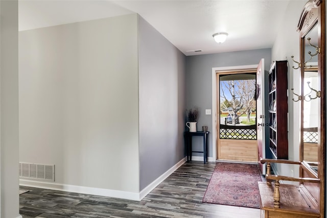 foyer featuring baseboards, visible vents, and dark wood-type flooring