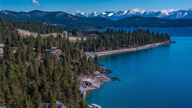 aerial view featuring a water and mountain view and a wooded view