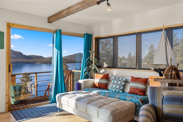 sunroom / solarium with a water view and beam ceiling