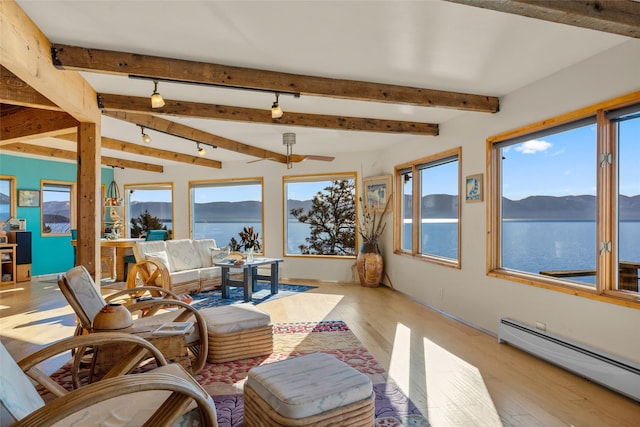 sunroom / solarium with baseboard heating, beam ceiling, and a water and mountain view