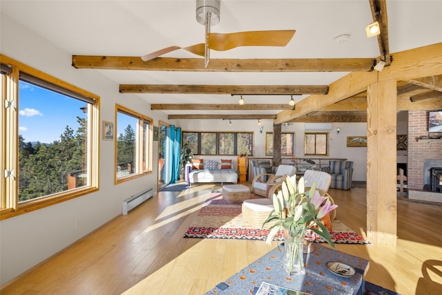 living area with wood-type flooring, baseboards, plenty of natural light, and baseboard heating