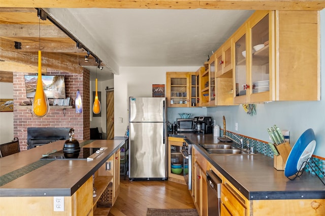 kitchen with dark countertops, appliances with stainless steel finishes, open shelves, a sink, and light wood finished floors