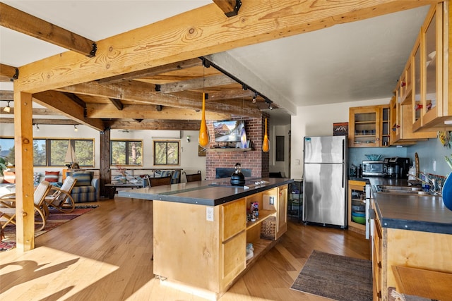 kitchen with dark countertops, light wood-style flooring, freestanding refrigerator, open floor plan, and beamed ceiling