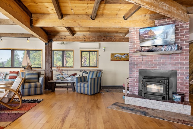 living area with an AC wall unit, beamed ceiling, wood ceiling, and hardwood / wood-style flooring
