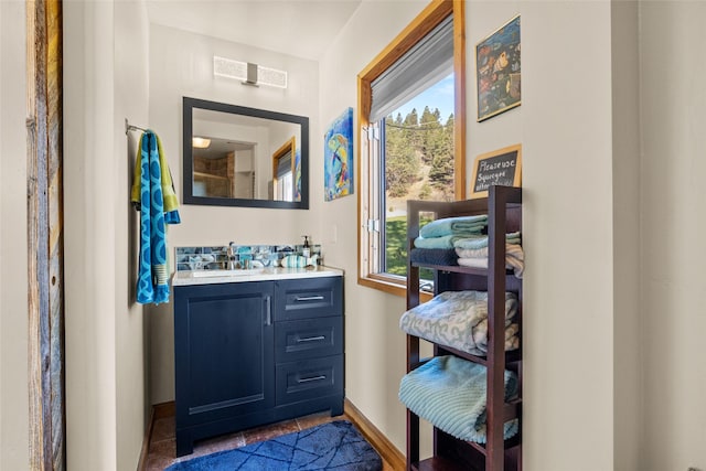 interior space with a sink, baseboards, plenty of natural light, and wet bar
