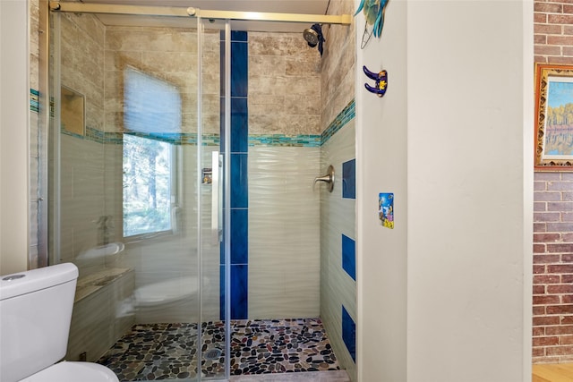 full bathroom with a stall shower, toilet, and brick wall