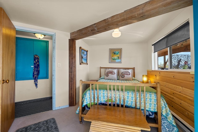 carpeted bedroom with a baseboard heating unit and beamed ceiling