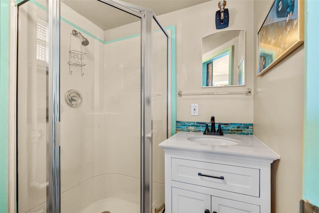 full bathroom with decorative backsplash, a shower stall, and vanity