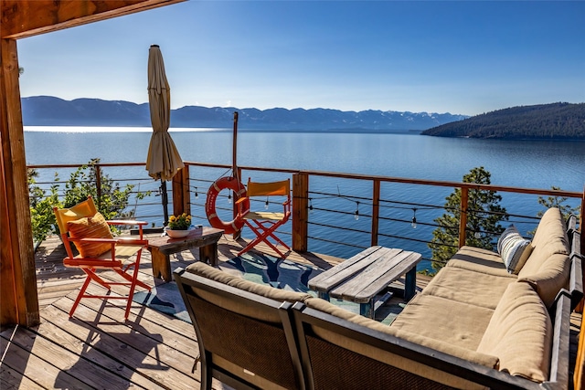 balcony featuring a water and mountain view and an outdoor hangout area