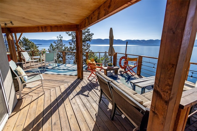 wooden terrace with a water and mountain view