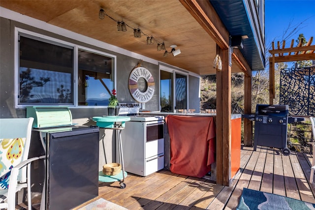 wooden deck with outdoor dry bar and a grill