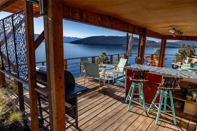 view of dock featuring a water and mountain view and outdoor dry bar