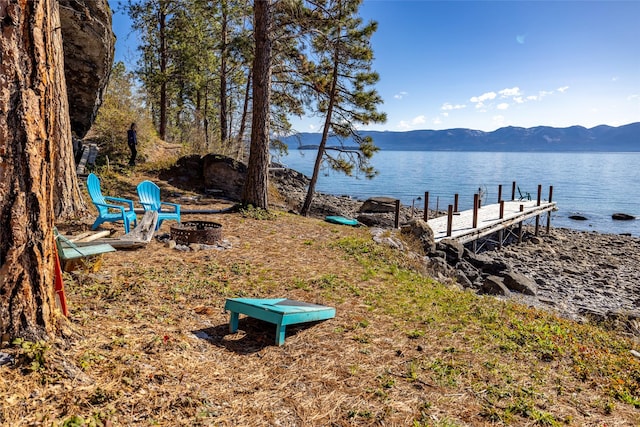 view of dock featuring a fire pit and a water and mountain view