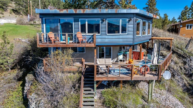 rear view of property featuring stairs and a deck