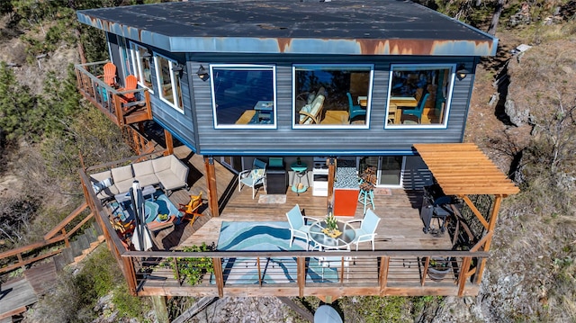 rear view of house with a deck and outdoor dining space