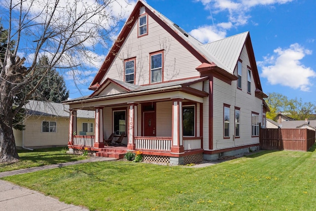 view of front of house with a front lawn, fence, and covered porch