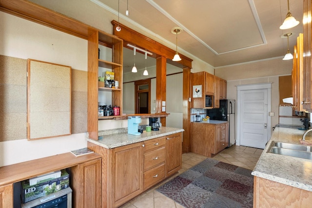 kitchen with brown cabinetry, a sink, light tile patterned floors, and light countertops