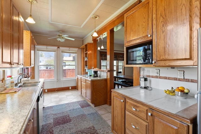 kitchen featuring brown cabinetry, a sink, pendant lighting, and a ceiling fan