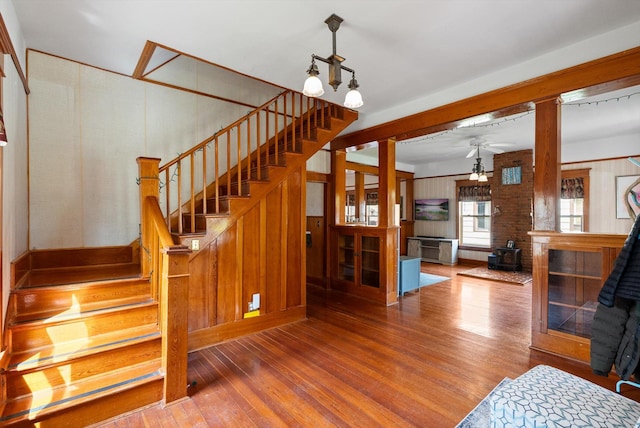 stairway featuring ceiling fan, a wood stove, and hardwood / wood-style floors