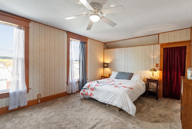 bedroom with carpet floors, multiple windows, and wallpapered walls