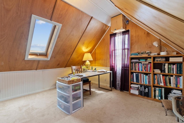 office area with wood walls, carpet, and vaulted ceiling with skylight