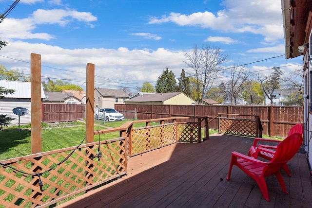 wooden terrace featuring fence, a yard, and a residential view