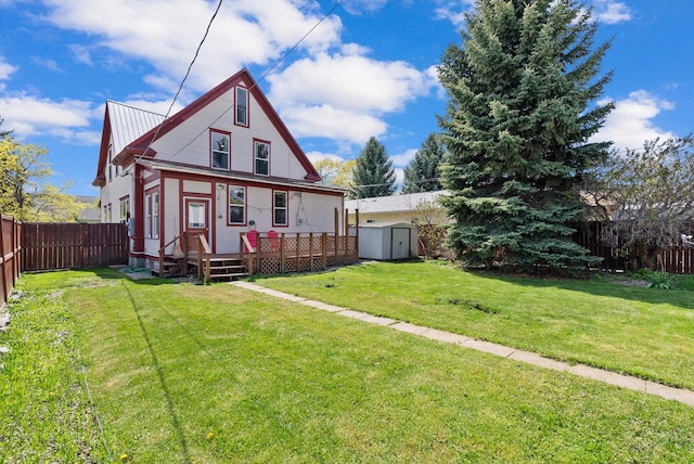 back of house featuring a storage unit, a fenced backyard, a yard, and an outdoor structure