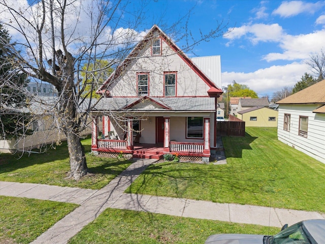victorian-style house featuring a porch and a front yard