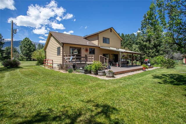 19720 Leo Hansen Rd, Florence, MT 59833 - rear view of house with a lawn and a deck with mountain view