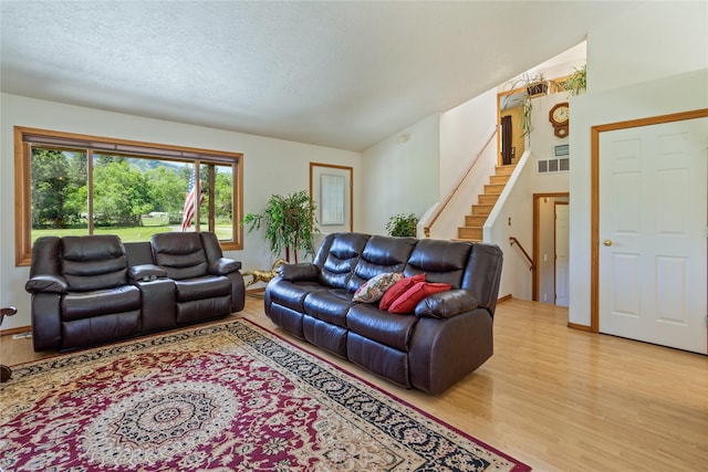 19720 Leo Hansen Rd, Florence, MT 59833 - living area with a textured ceiling, light wood finished floors, stairs, and visible vents