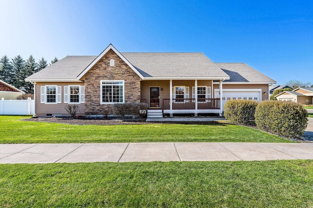 view of front of home featuring a garage, a front lawn, fence, covered porch, and stone siding