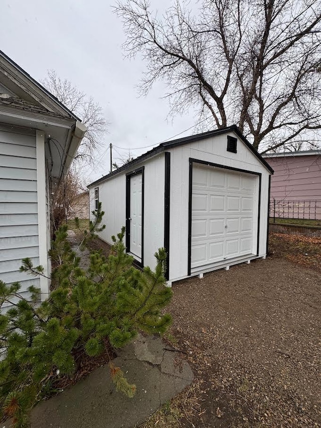 garage featuring fence and driveway