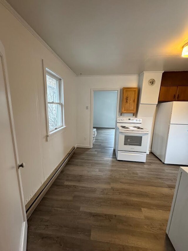 kitchen with brown cabinetry, ornamental molding, white appliances, baseboards, and dark wood finished floors