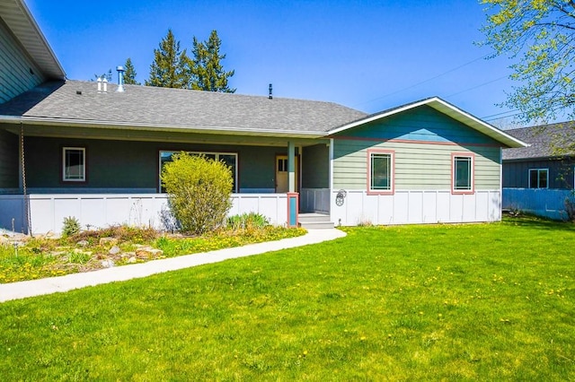 single story home featuring a porch, a shingled roof, and a front yard