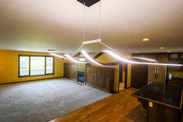 bonus room featuring a fireplace, recessed lighting, baseboards, and dark wood-type flooring