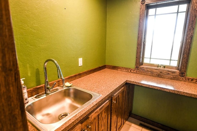 kitchen featuring a sink, plenty of natural light, and a textured wall