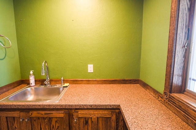bar featuring a sink and a textured wall