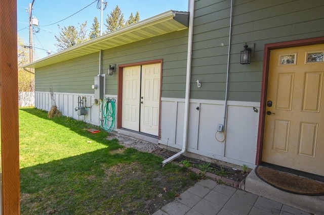 view of exterior entry featuring a yard