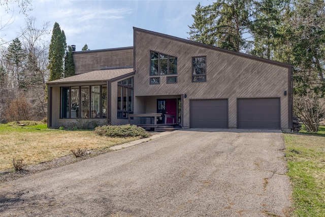 view of front of house featuring a porch, a front lawn, and driveway