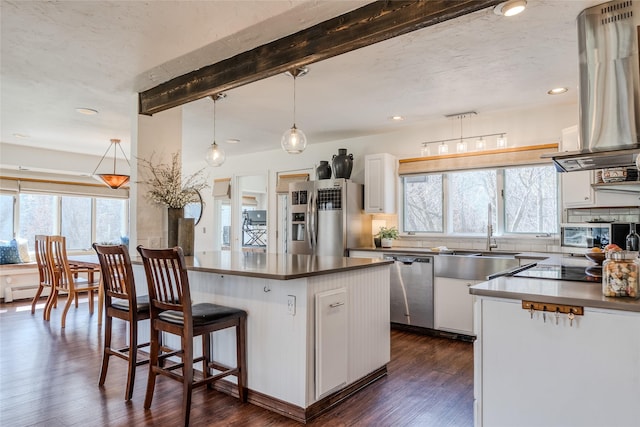 kitchen featuring island exhaust hood, a sink, beamed ceiling, stainless steel appliances, and dark wood-type flooring