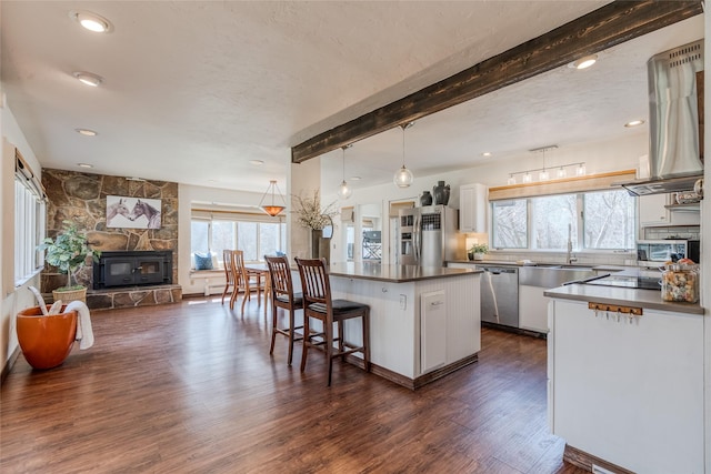kitchen featuring dark countertops, open floor plan, white cabinets, dark wood finished floors, and stainless steel appliances