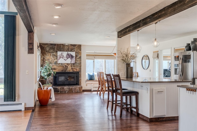 kitchen featuring white cabinets, open floor plan, wood finished floors, stainless steel refrigerator with ice dispenser, and a baseboard heating unit