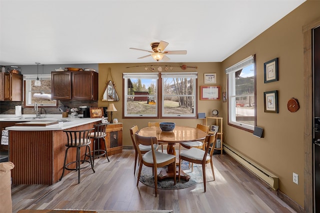 17 S Main St, Neihart, MT 59465 - dining space with baseboards, a baseboard radiator, light wood-type flooring, and ceiling fan