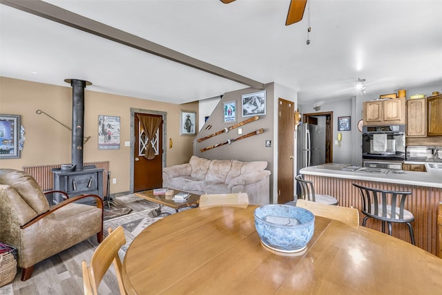 17 S Main St, Neihart, MT 59465 - dining room featuring a ceiling fan, light wood-style flooring, and a wood stove