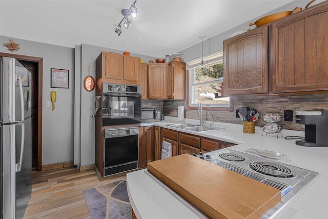 17 S Main St, Neihart, MT 59465 - kitchen featuring a sink, light countertops, freestanding refrigerator, light wood-type flooring, and backsplash