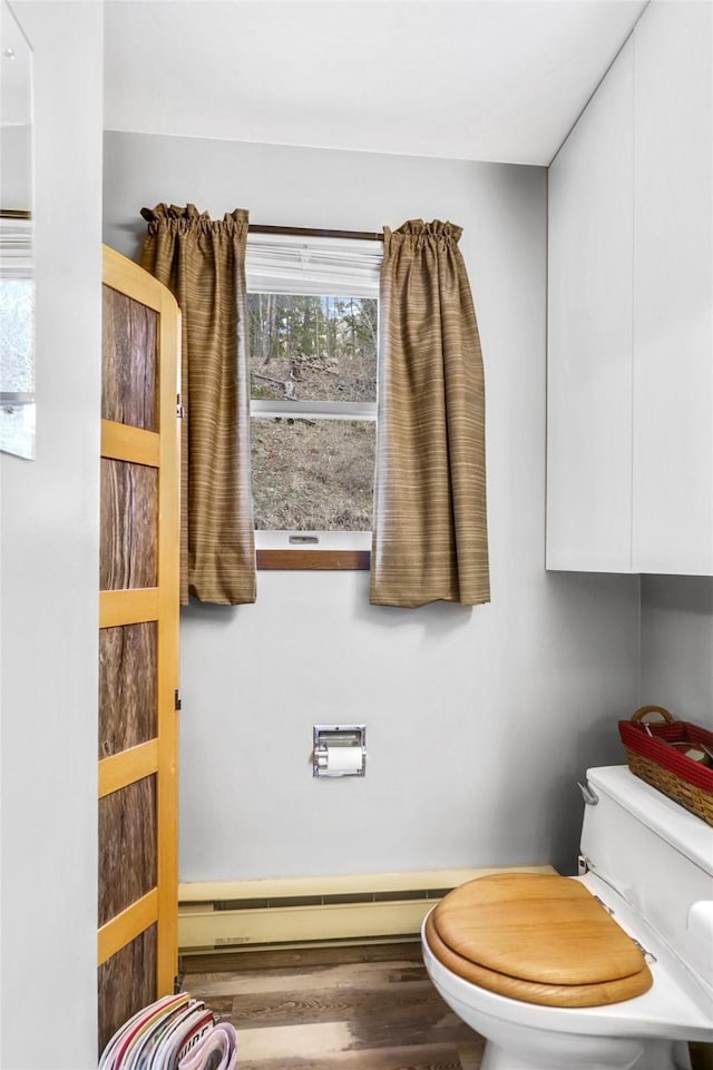 17 S Main St, Neihart, MT 59465 - bathroom featuring toilet, a baseboard heating unit, and wood finished floors