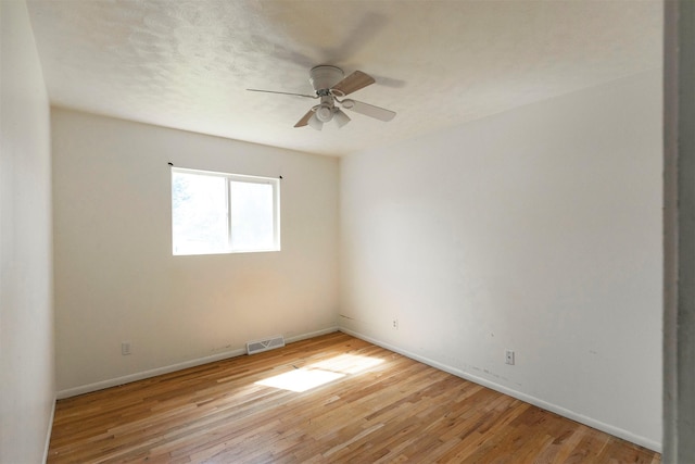 spare room featuring visible vents, baseboards, ceiling fan, and light wood-type flooring